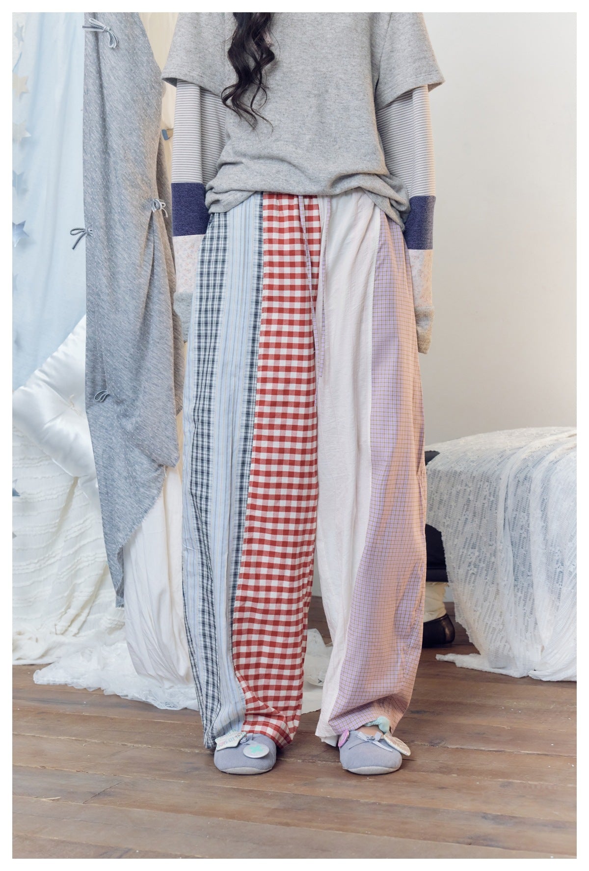 Lower-body view of a model in wide-leg patchwork pants with red gingham, plaid, white and lavender check panels