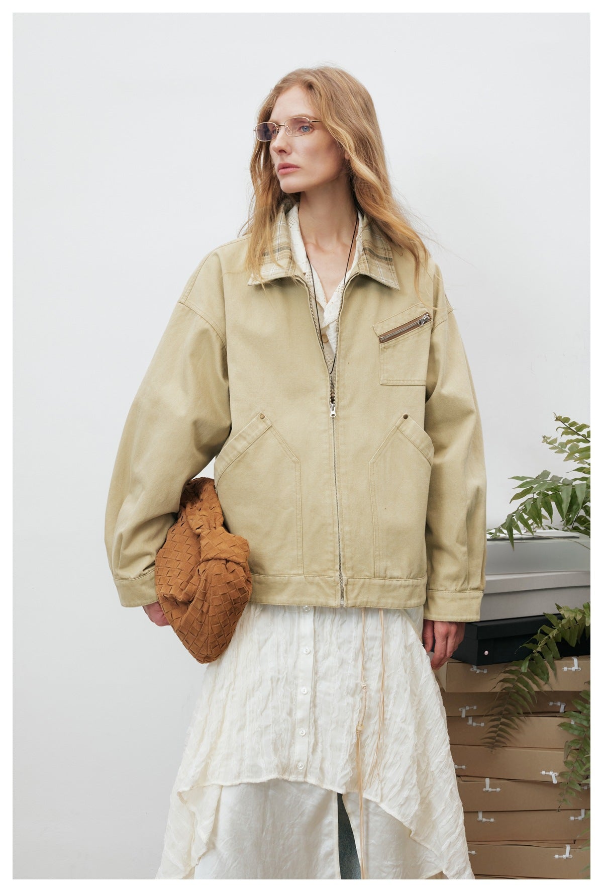 Model in a beige jacket with a plaid collar, front zip, two lower pockets, and a zip chest pocket.