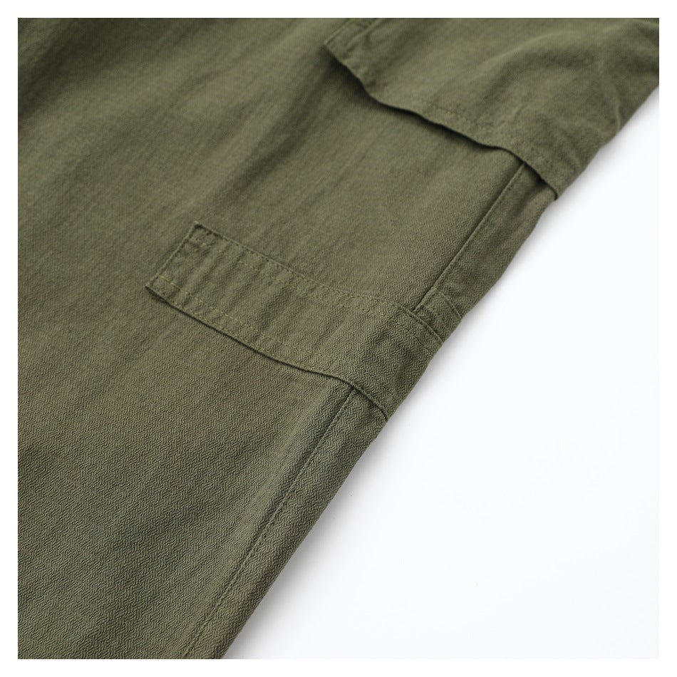 Close-up of an olive cargo pant leg showing the large side pocket and stitching.