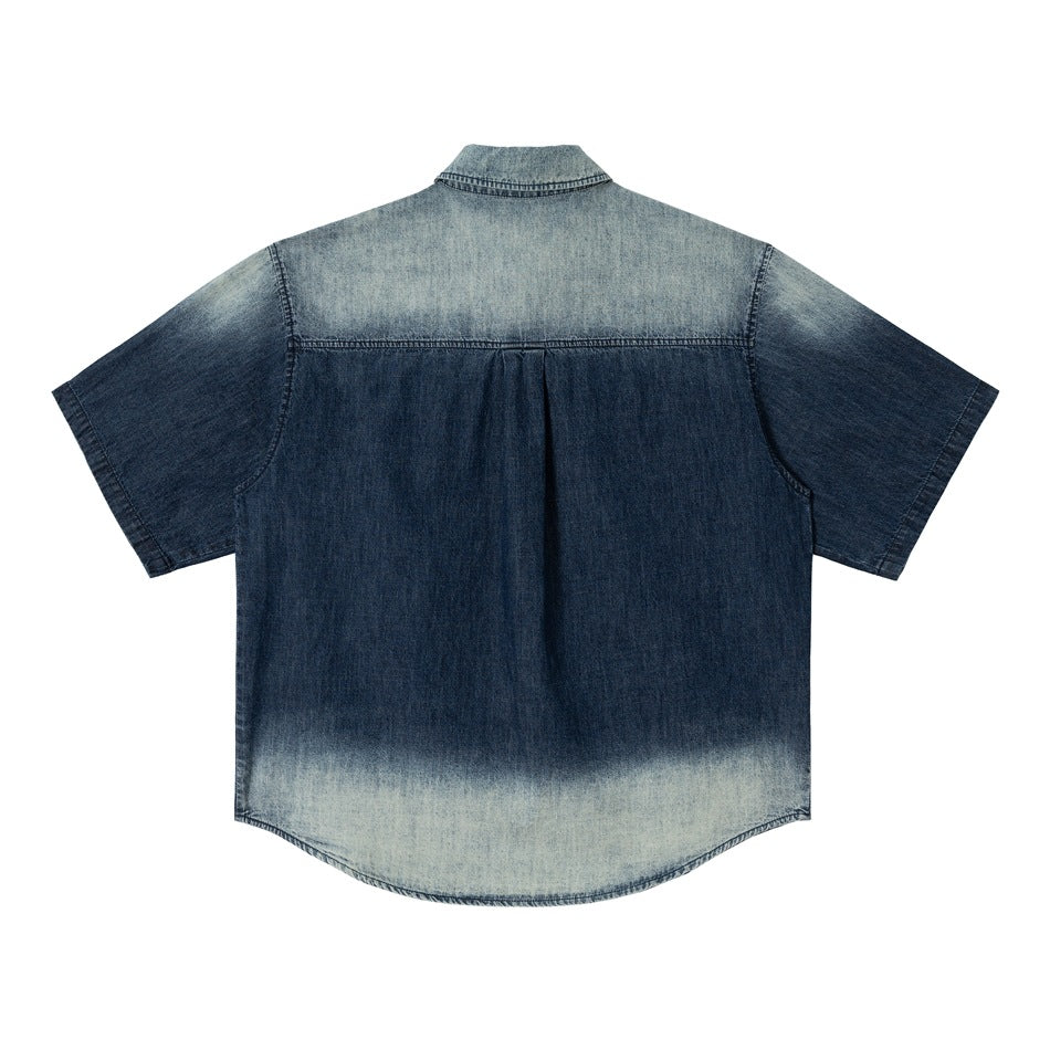 Back of faded blue denim short-sleeve shirt with light yoke, center pleat and light faded hem