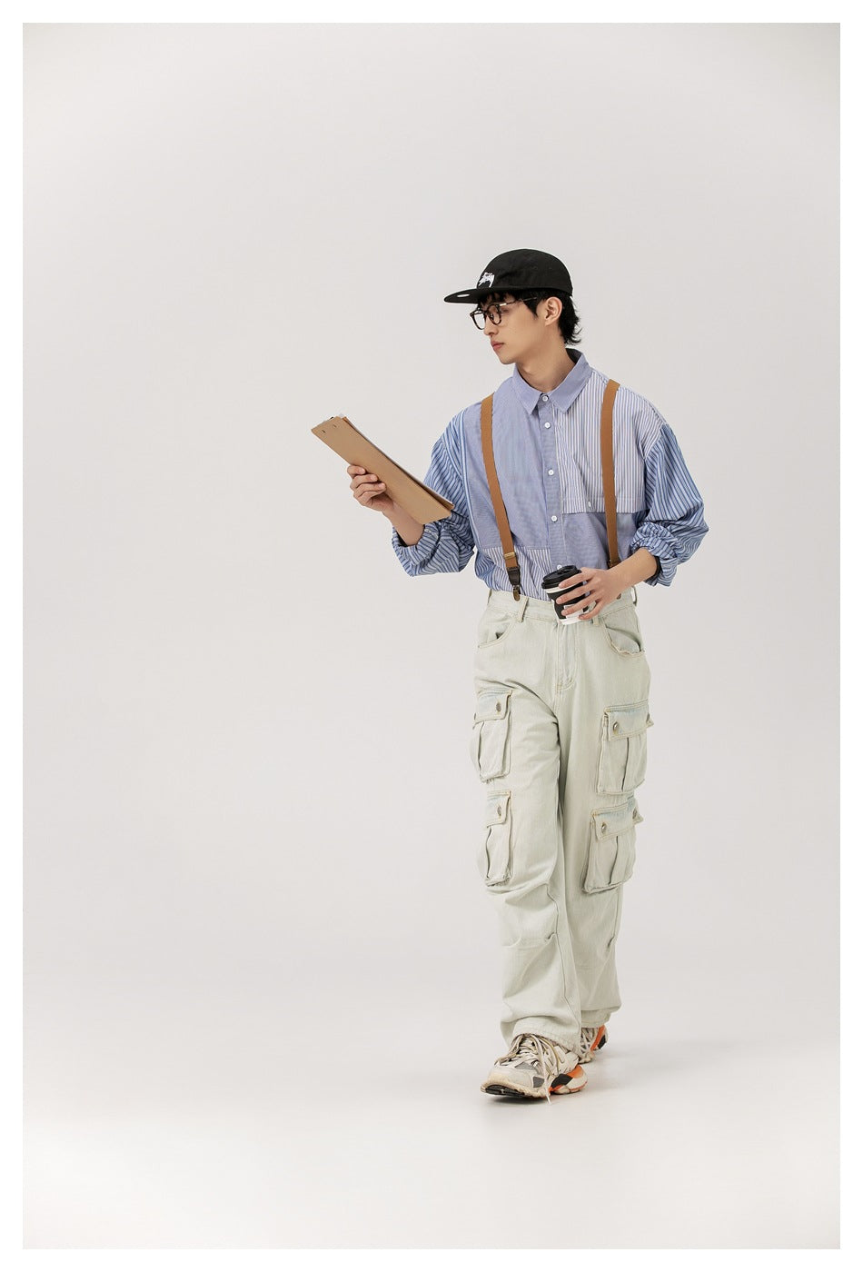 Full-length view of a model wearing a blue striped patchwork shirt with a button front and chest pocket.