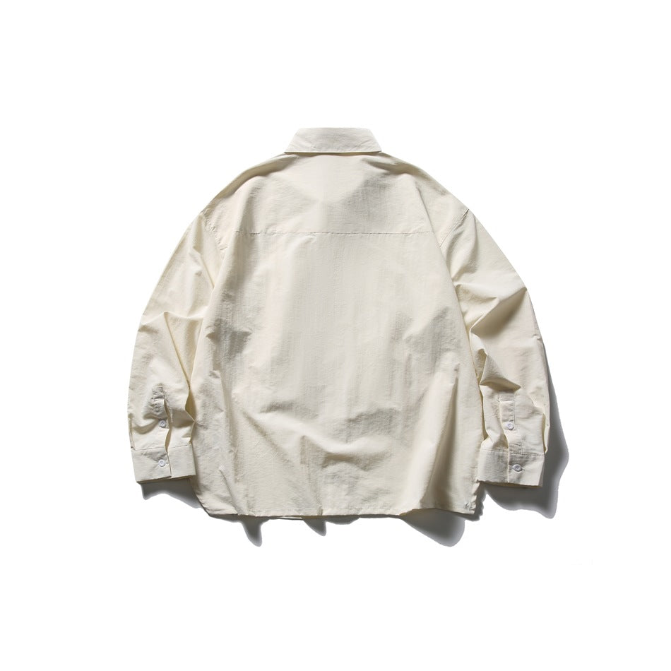 Rear view of an off-white long-sleeve collared shirt laid flat against a white background.