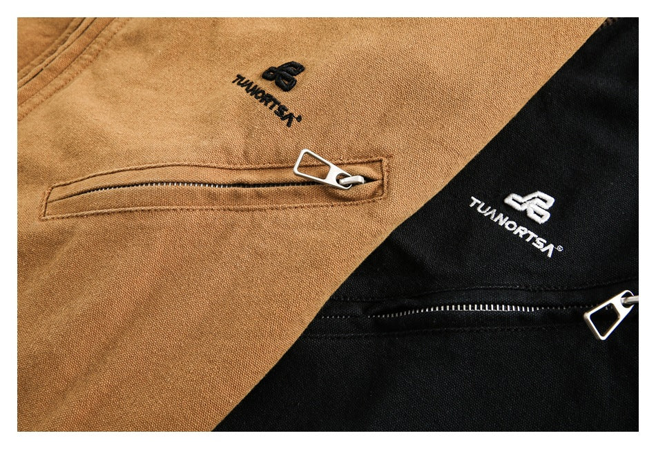 Close-up of tan and black jacket fabric with embroidered logos and horizontal zip pockets.