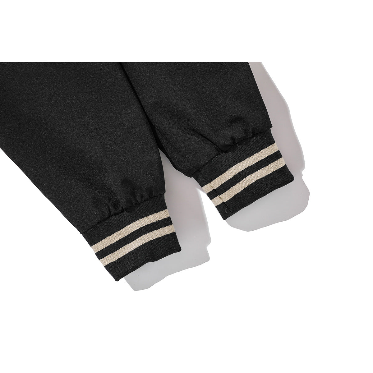 Close-up of the black jacket's sleeves and black cuffs with two cream stripes.