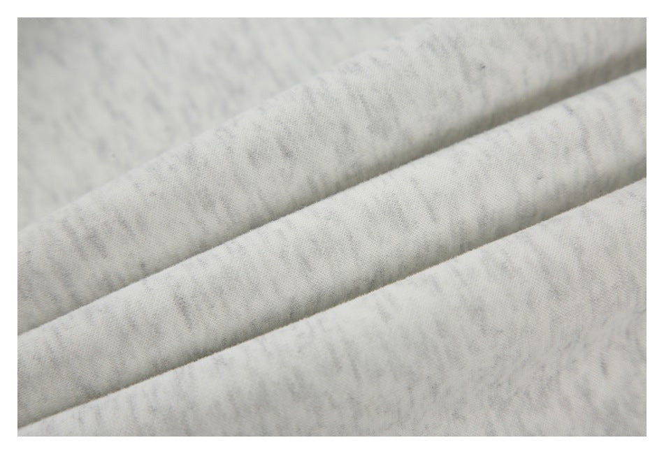 Macro view of folded light gray marled shirt fabric showing its surface texture.