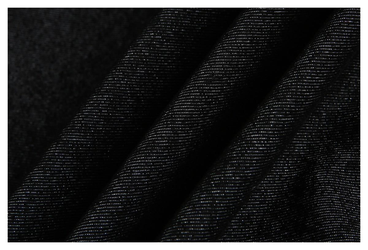 Close-up of black fabric draped in folds, showing its fine striped texture.