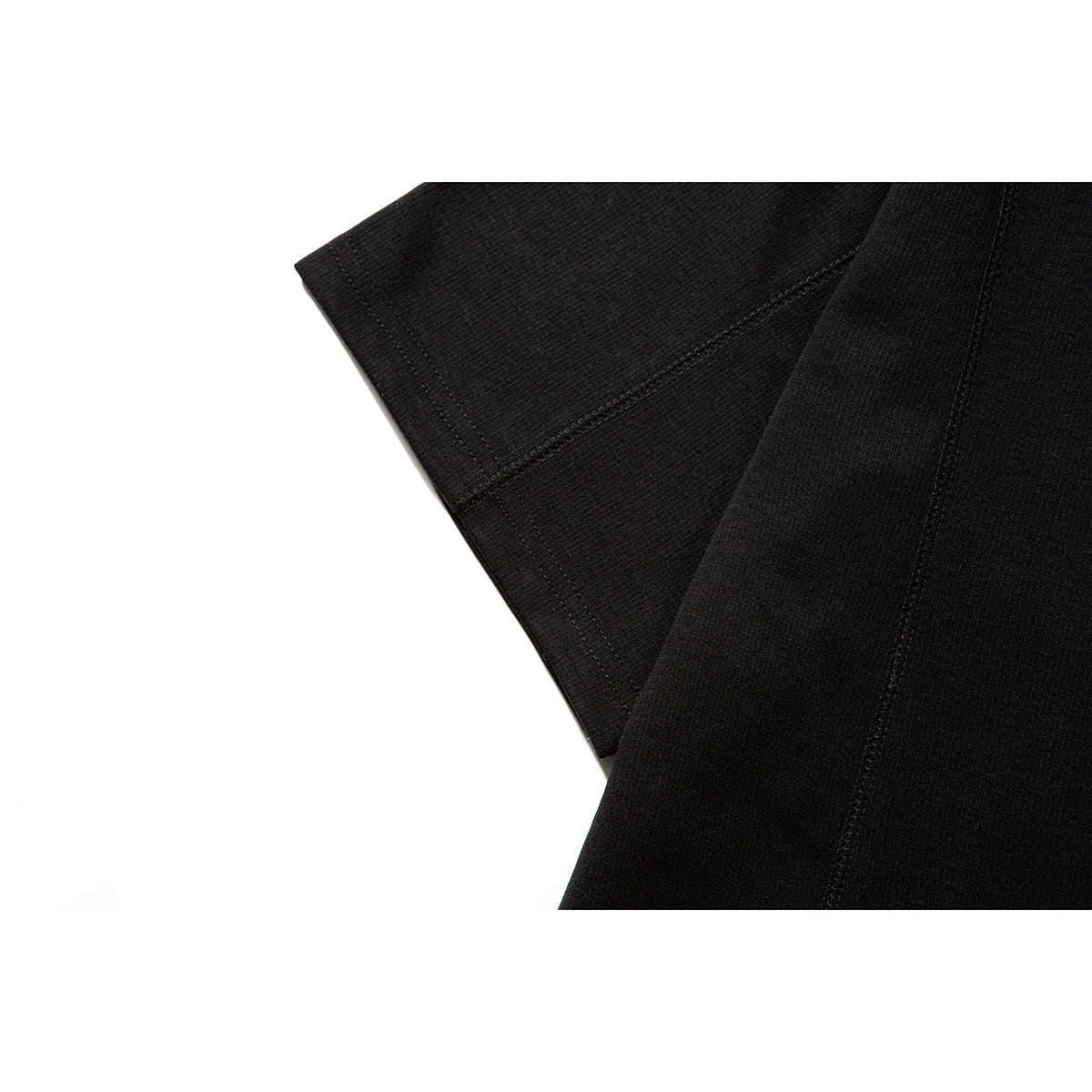 Close-up of a black T-shirt sleeve and adjoining body panel, highlighting the stitched seams and fabric surface.