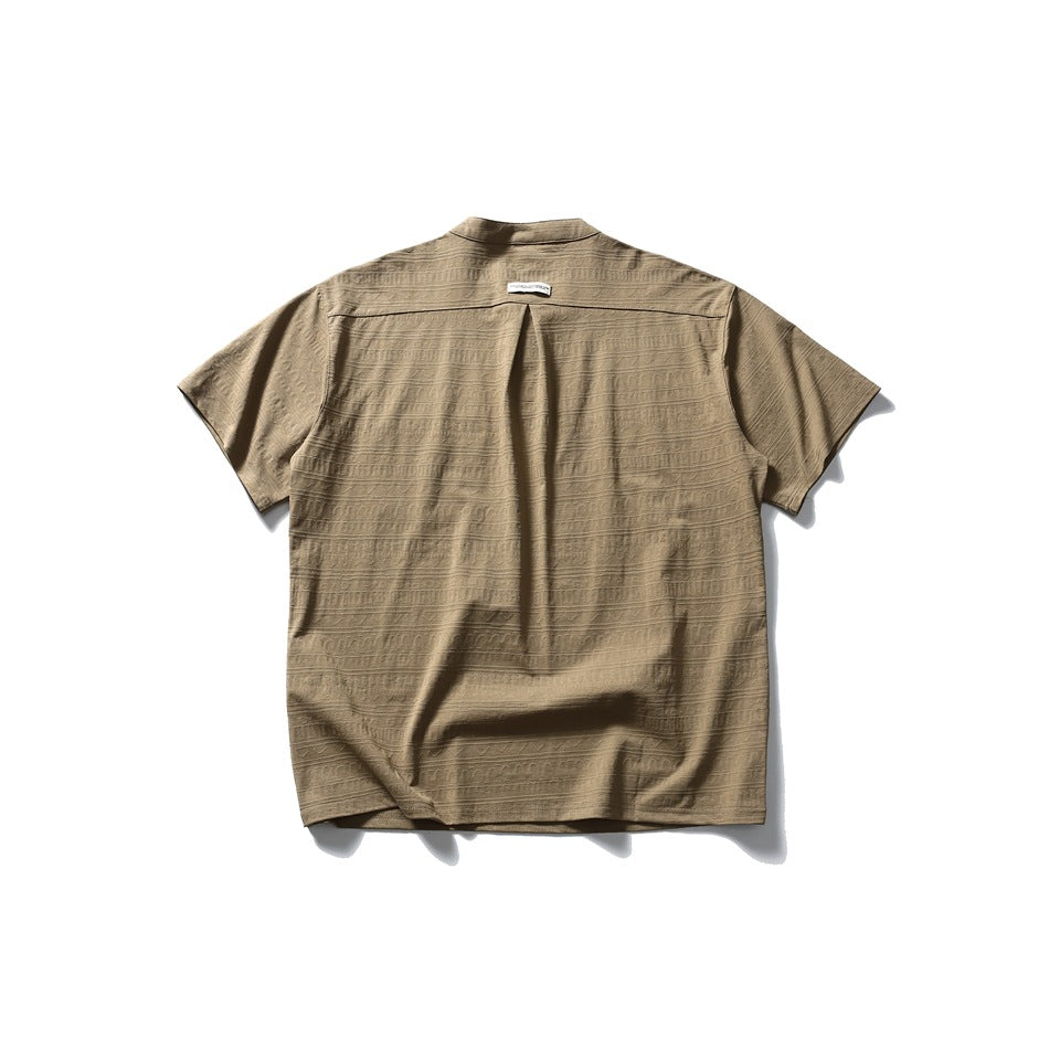 Back view of a tan short-sleeve shirt with a subtle allover geometric texture and a center back pleat.
