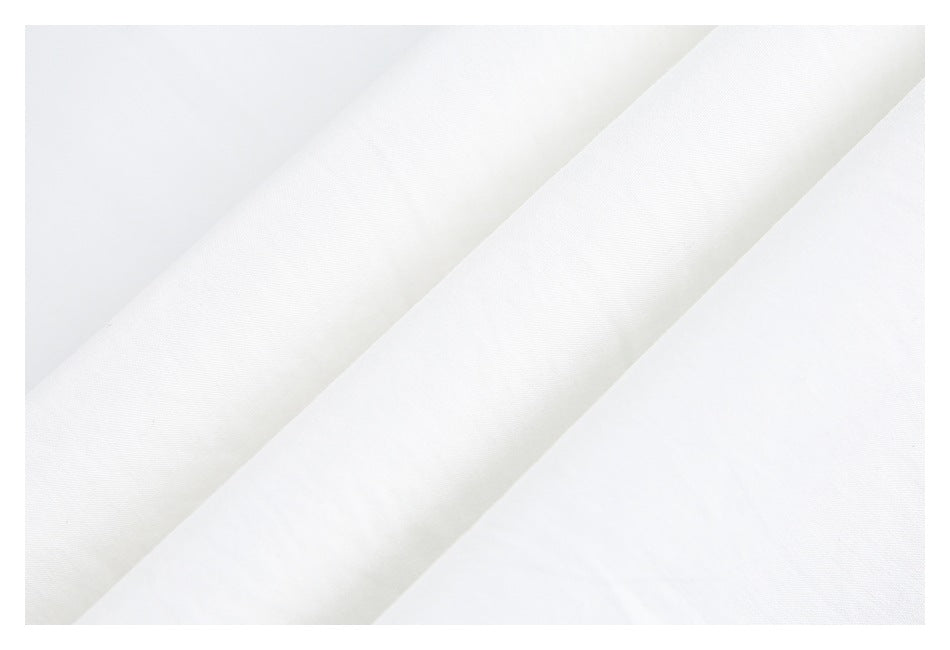 Close-up of white fabric folds showing a subtle woven texture.