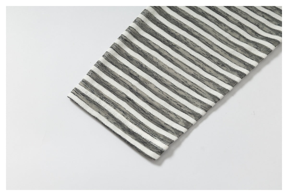 Close-up of a gray-and-white striped sleeve with a stitched edge.
