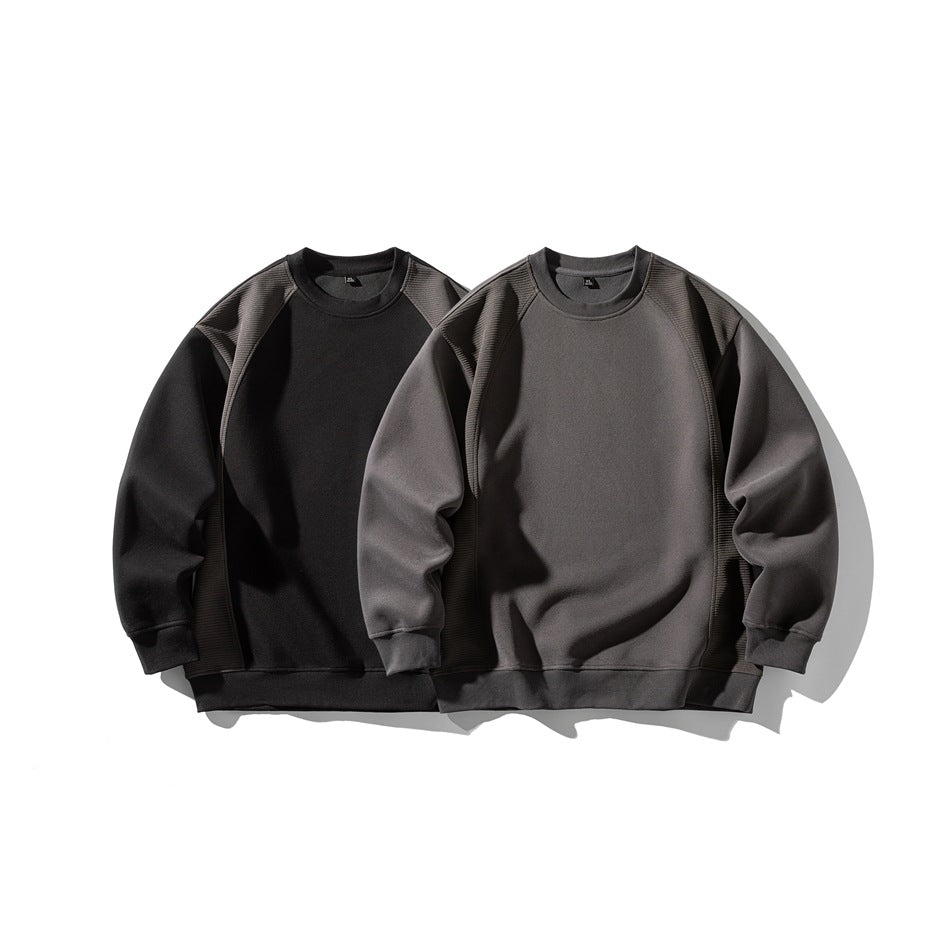 Two crewneck sweatshirts shown together: black and charcoal gray, both with textured contrast panels.