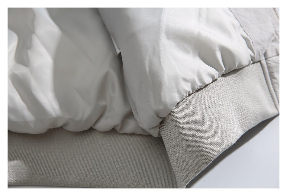 Close-up of the light gray jacket's gathered sleeve and ribbed knit cuff and hem.
