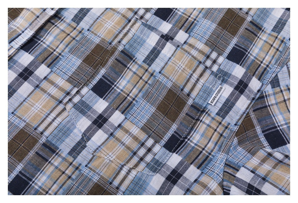 Close-up of a plaid shirt chest pocket and small woven brand tab.