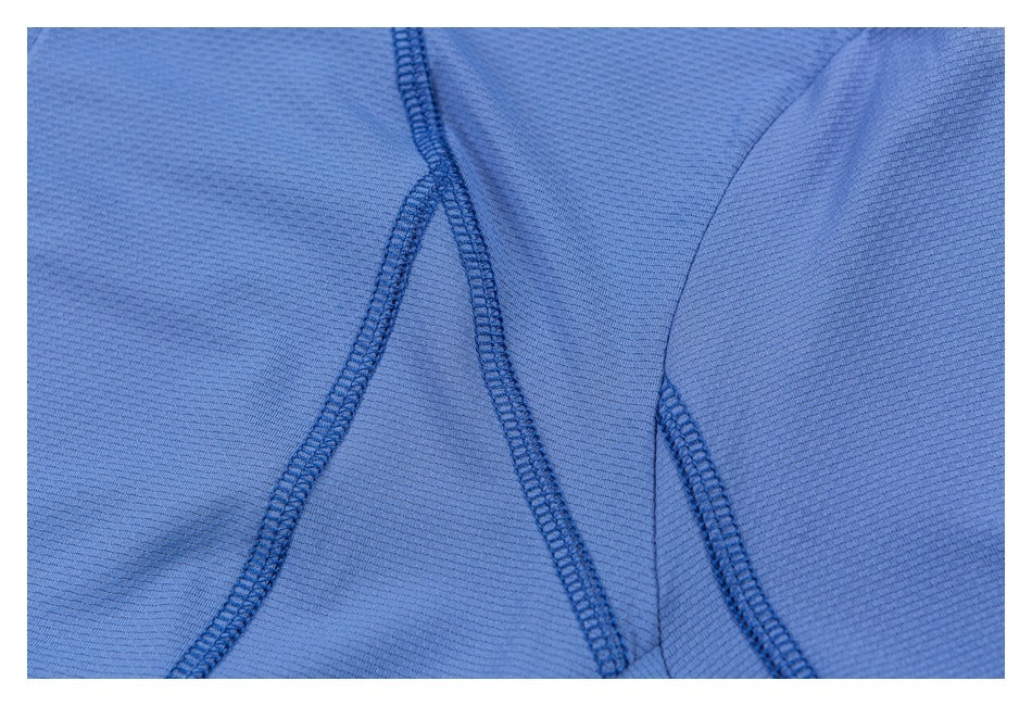 Close-up of curved reinforced seams on blue garment fabric.