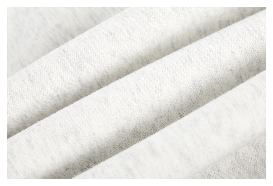 Close-up of folded light heather-gray sweatshirt fabric showing its surface texture.