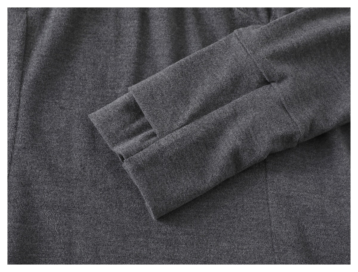 Close-up of a charcoal gray garment sleeve and finished cuff laid across the fabric.