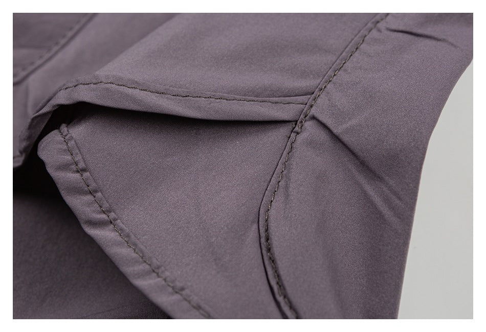 Close-up of mauve-gray shorts showing stitched seams and a folded fabric edge.