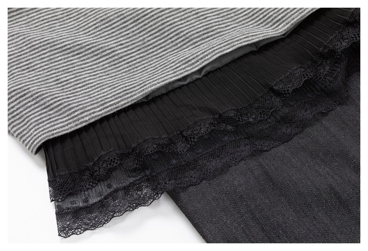 Close-up of a gray striped outer layer over black pleated fabric with a scalloped lace trim.