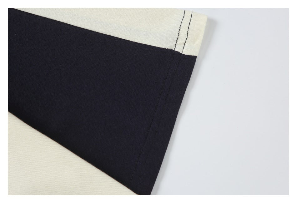 Close-up of the black sleeve panel, cream sleeve edge, and double-stitched cuff.