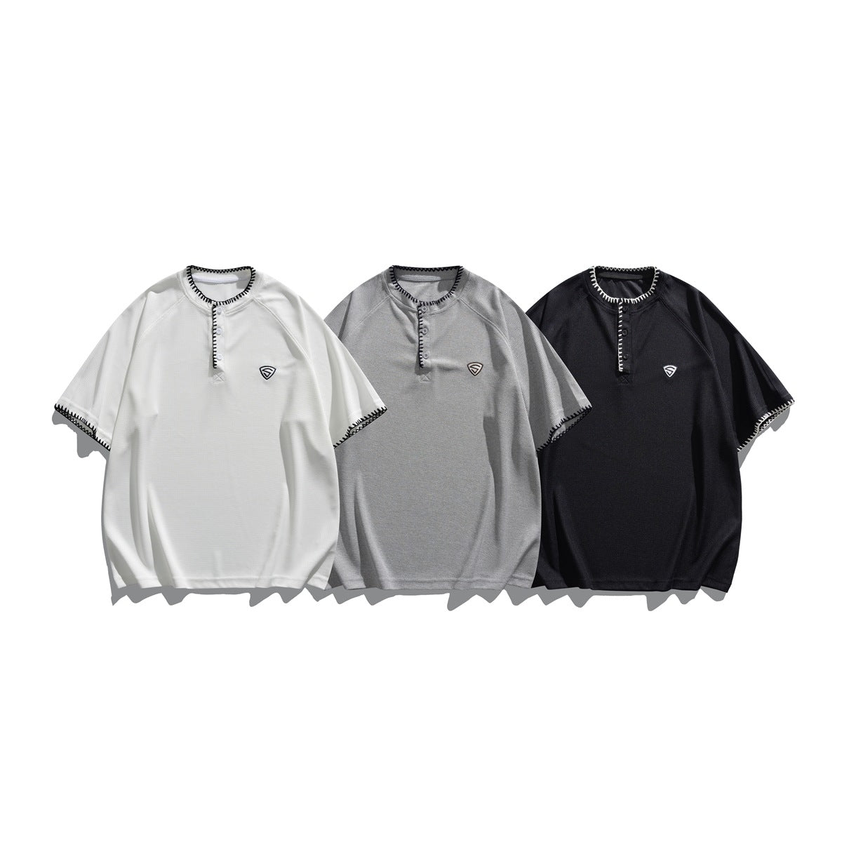 Three short-sleeve shirts shown from the front in white, light gray, and black, with contrast stitching and button plackets.