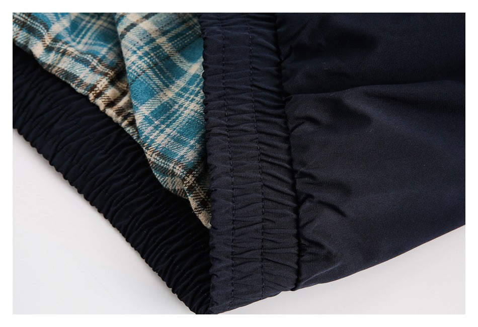 Close-up of a gathered dark navy waistband with blue-and-cream plaid lining visible inside.