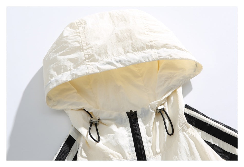 Close-up of the ivory jacket's hood, black front zipper, and adjustable drawcords.