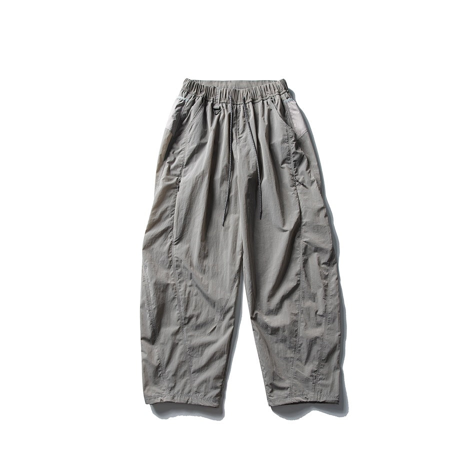 Light gray wide-leg drawstring pants with curved leg seams, flat lay front view