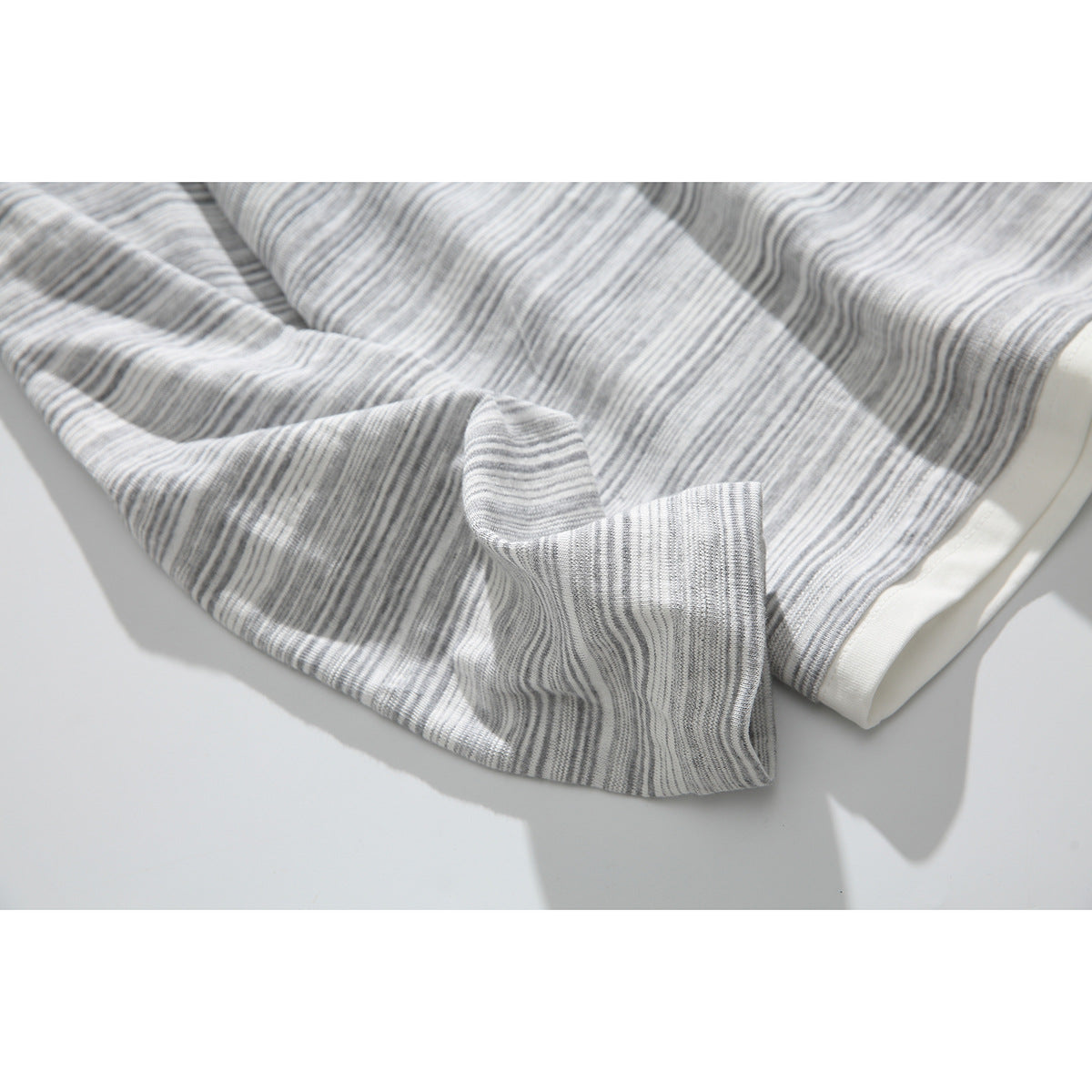 Close-up of the gray-and-white striped shirt fabric and sleeve cuff.