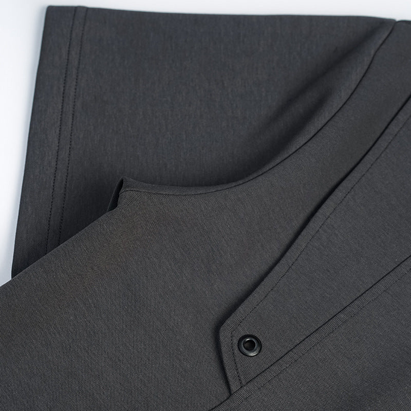 Close-up of a charcoal T-shirt showing its curved seam, shoulder panel, and black snap fastener.
