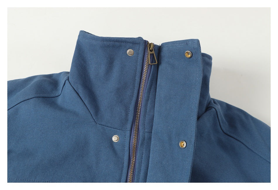 Close-up of a blue jacket's front zipper and snap-fastened storm flap.