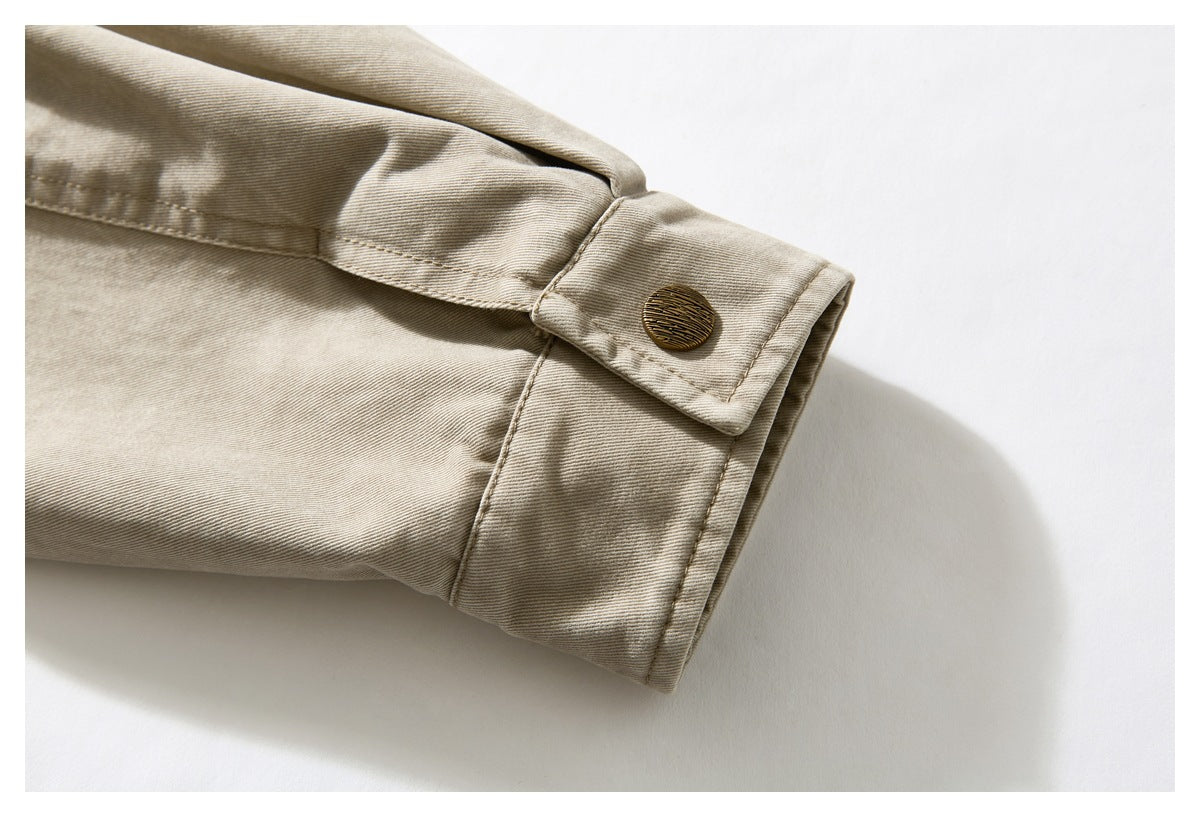 Close-up of a beige jacket sleeve cuff with a brown button and stitched seams.