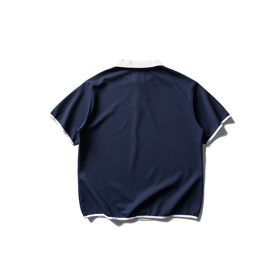 Back view of navy short-sleeve polo with white collar and white trim on sleeves and hem, flat lay