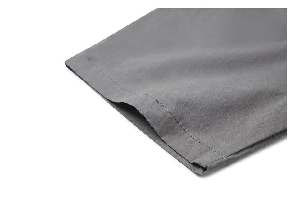 Close-up of the stitched hem on a gray shirt sleeve.