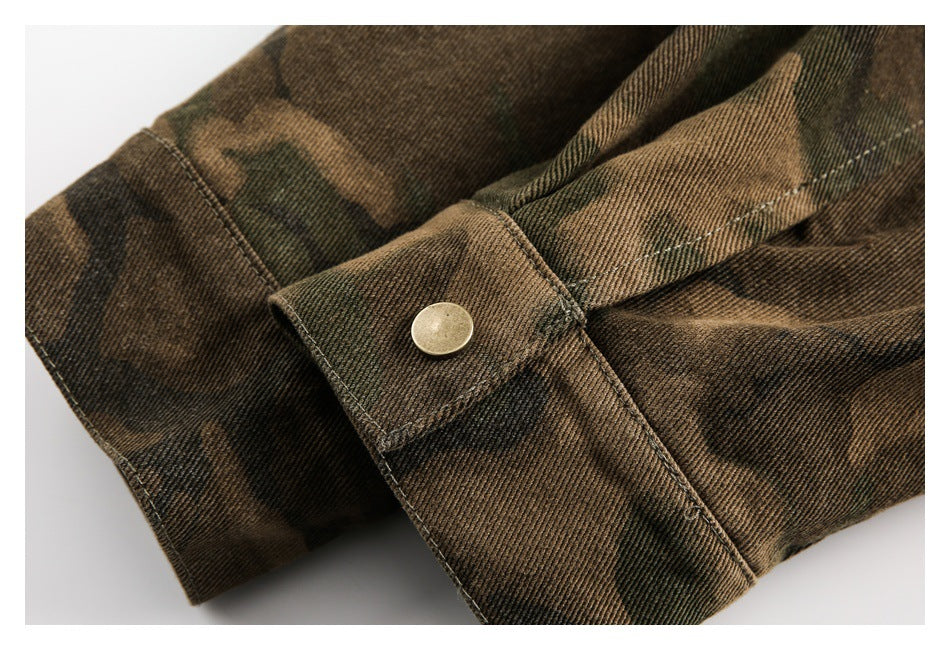Close-up of a camouflage sleeve cuff with a round metal snap button and stitched seams.