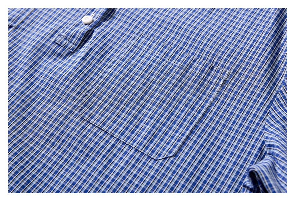 Close-up of a patch pocket on a blue, navy, and white checked shirt.