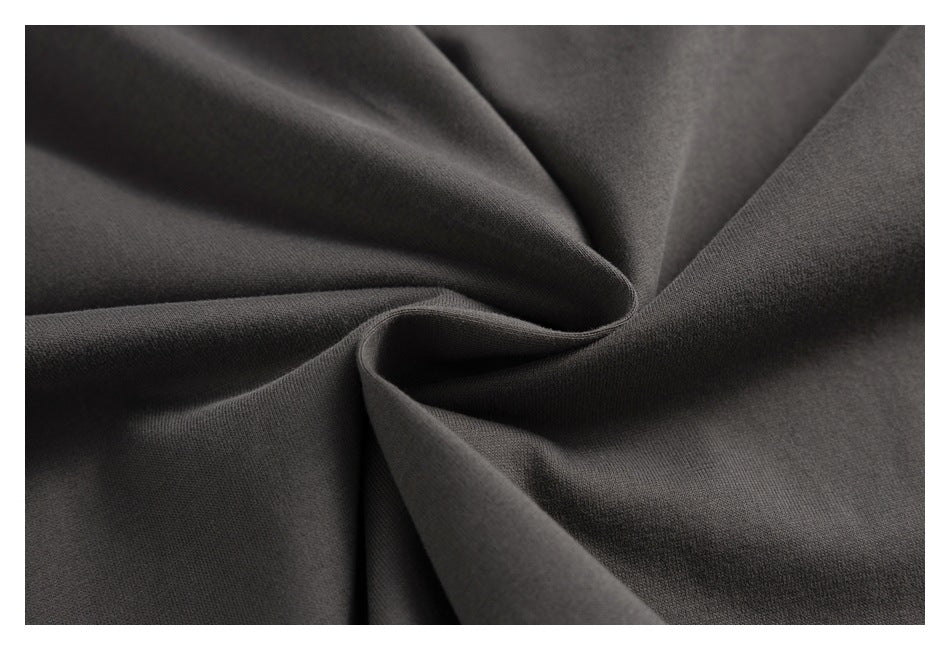 Close-up of dark charcoal fabric gathered into soft folds.