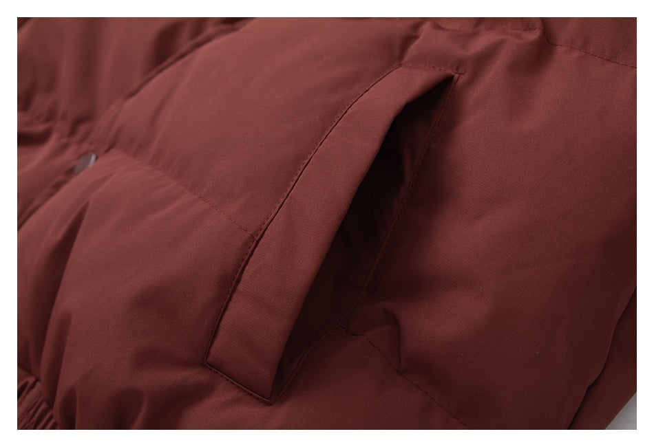 Close-up of the burgundy jacket's angled side pocket opening and stitching.