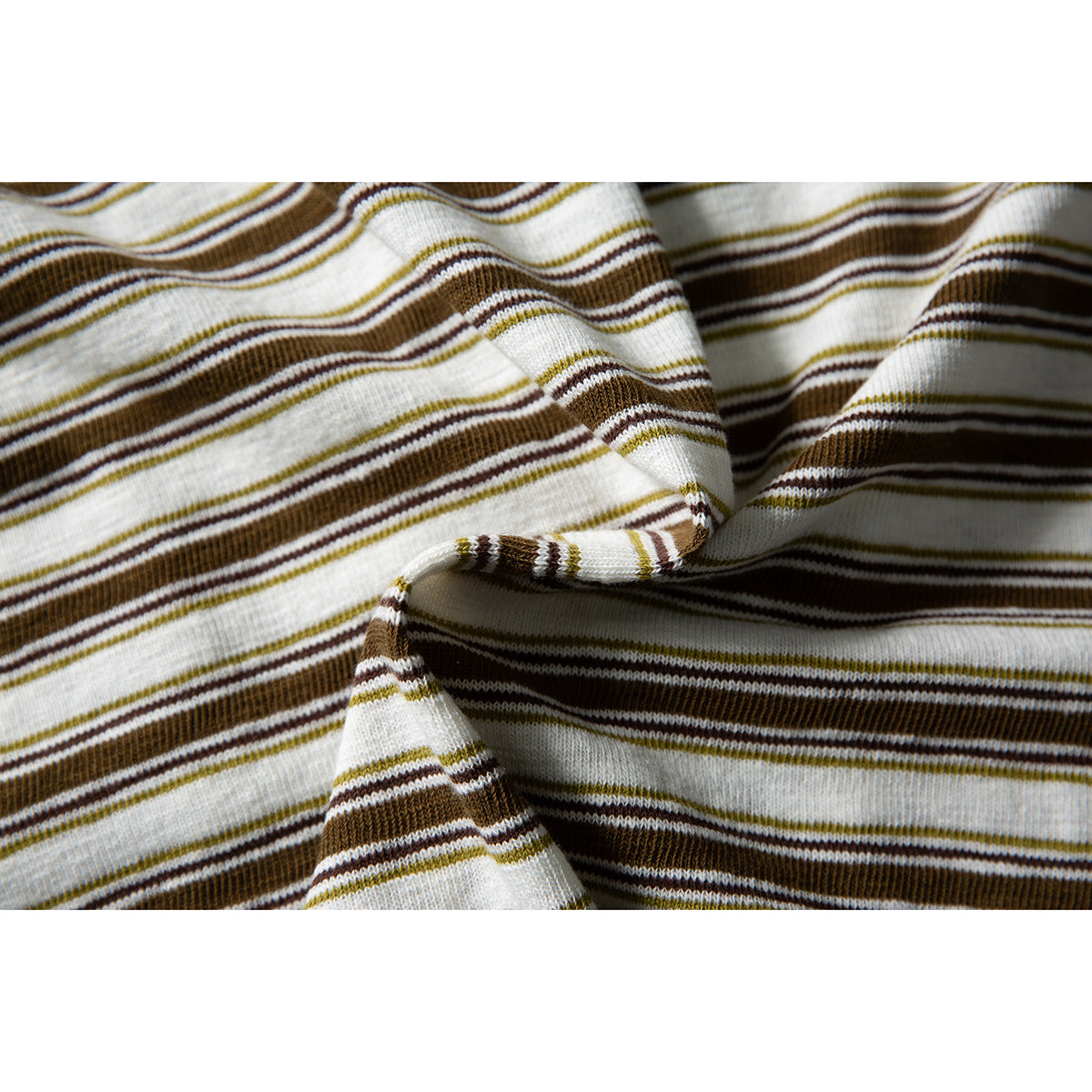 Close-up of the cream shirt's brown and olive striped fabric, draped to show its folds and edge.
