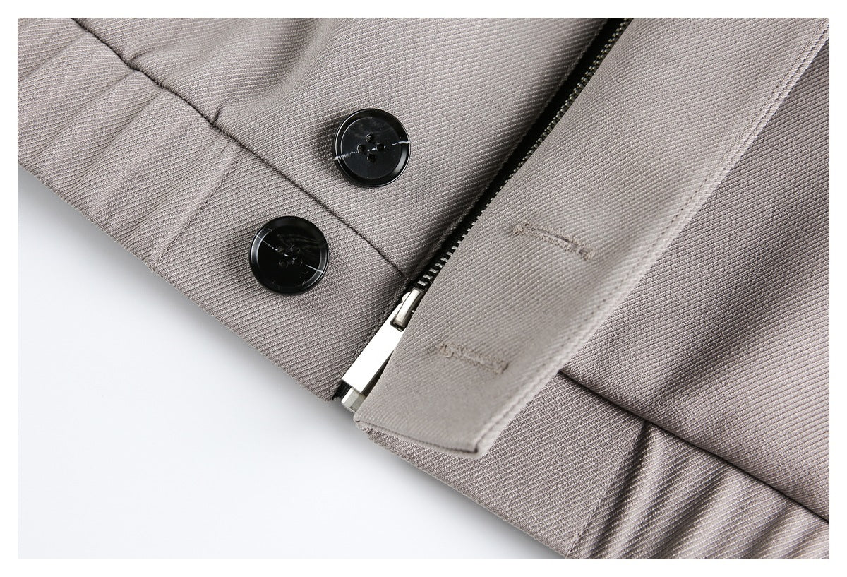 Close-up of the taupe-gray coat front with two black buttons and a partially covered zipper.