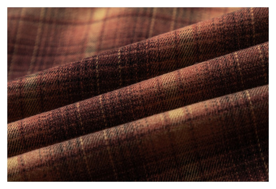 Macro view of brown plaid fabric folded to show its woven texture.