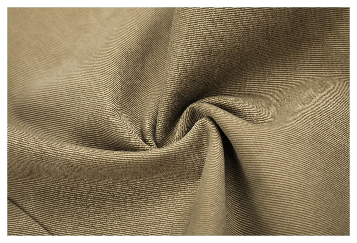 Close-up of khaki trouser fabric gathered into folds, showing its fine diagonal texture.