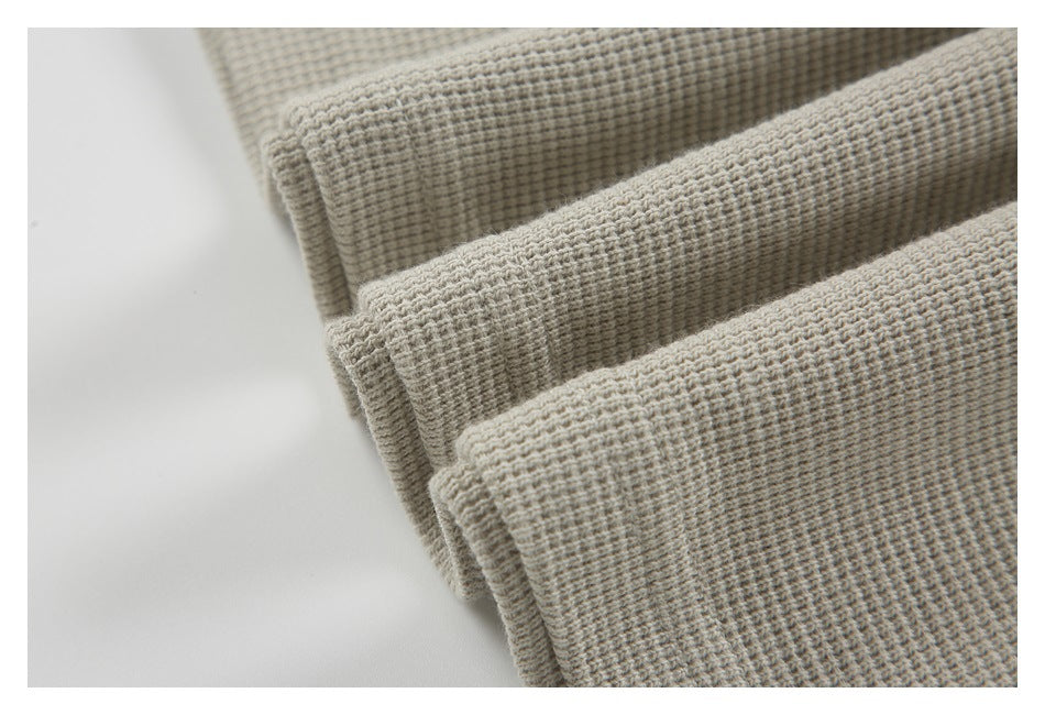 Close-up of folded edges showing the pullover's thick, textured light beige fabric.