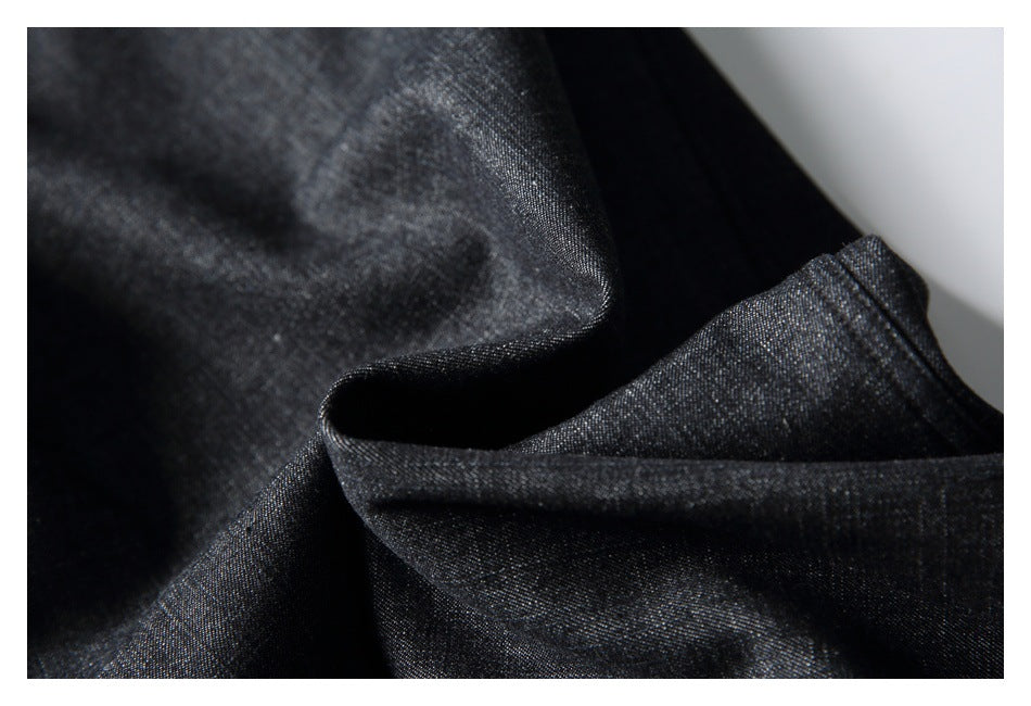 Close-up of dark charcoal fabric with a subtle woven texture and soft folds.