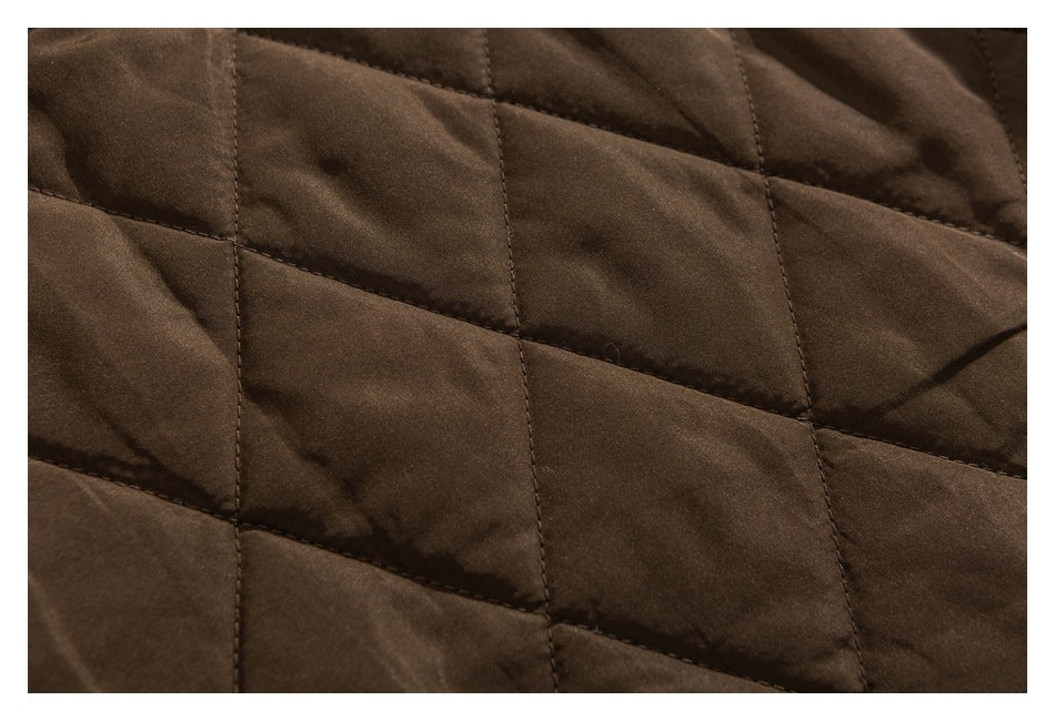 Close-up of dark brown quilted garment fabric with large diamond stitching.