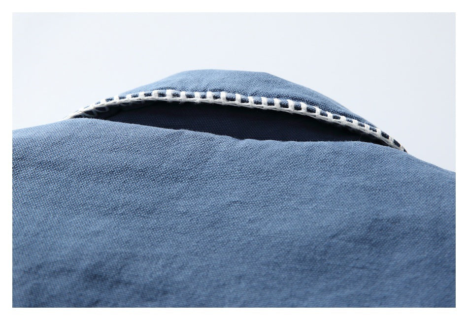 Close-up of a dark blue collar edge with prominent pale contrast stitching.
