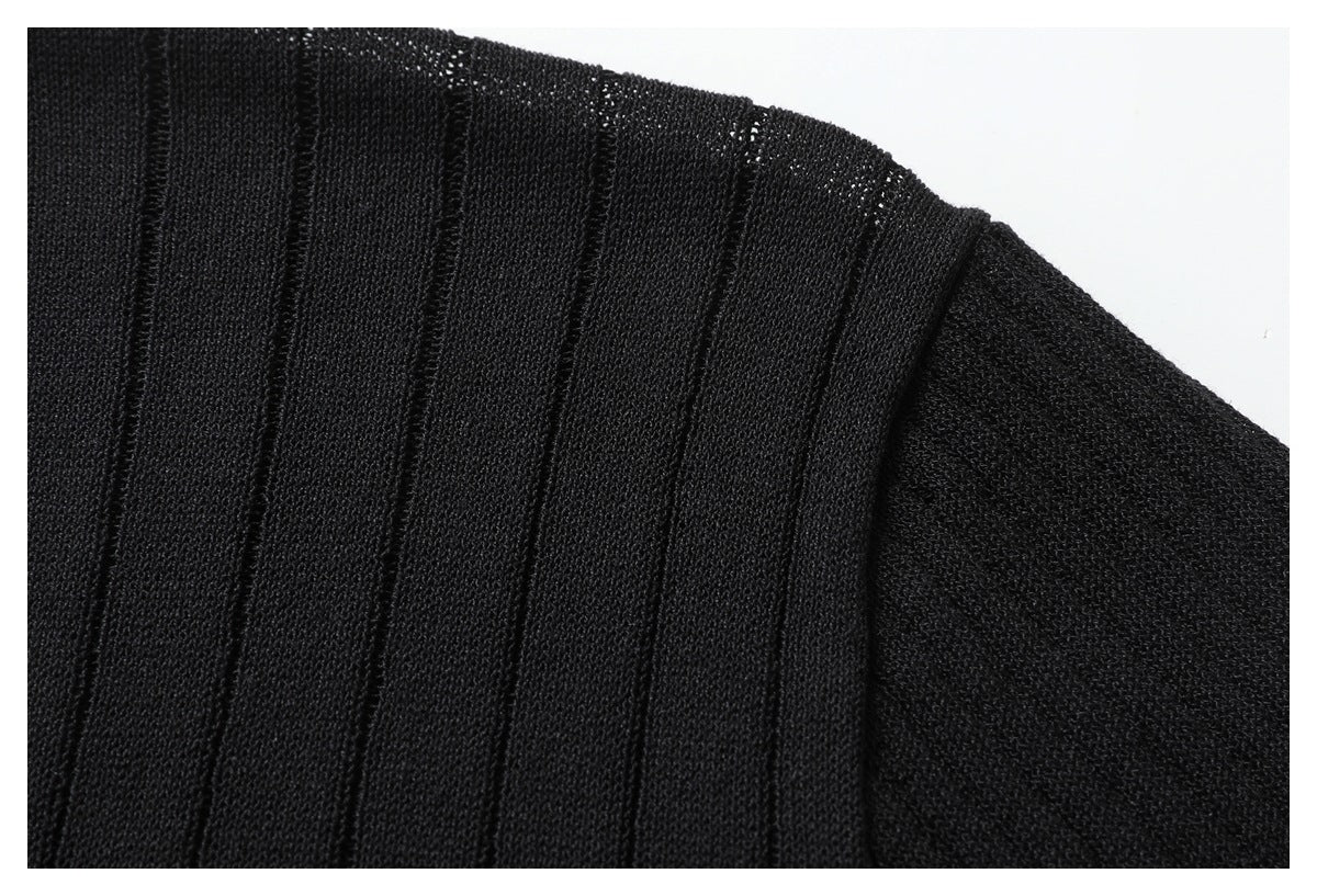 Close-up of the black top's ribbed shoulder panel and sleeve seam.