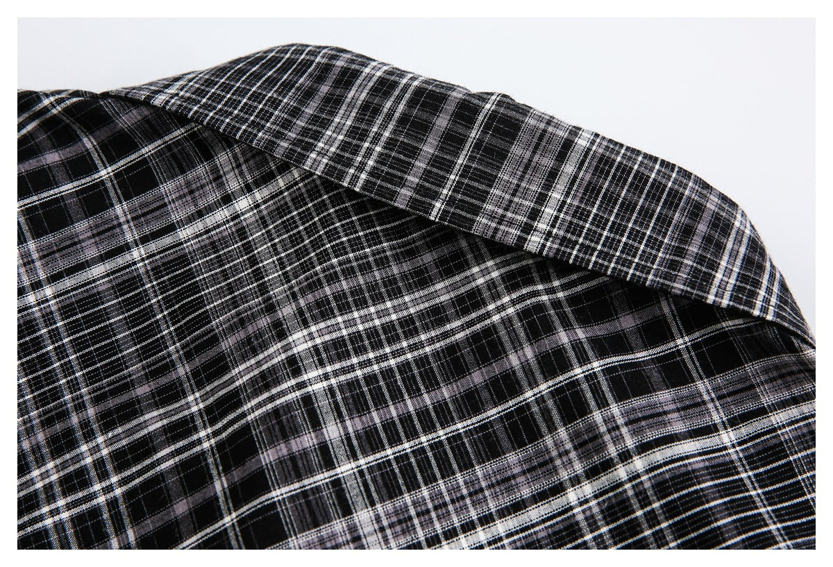 Close-up of black, white, and gray plaid fabric folded to show its pattern and texture.