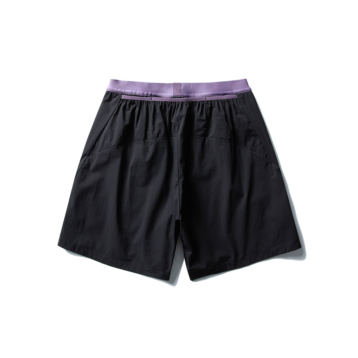 Back view of loose black shorts with a lavender waistband and curved rear panel seams.