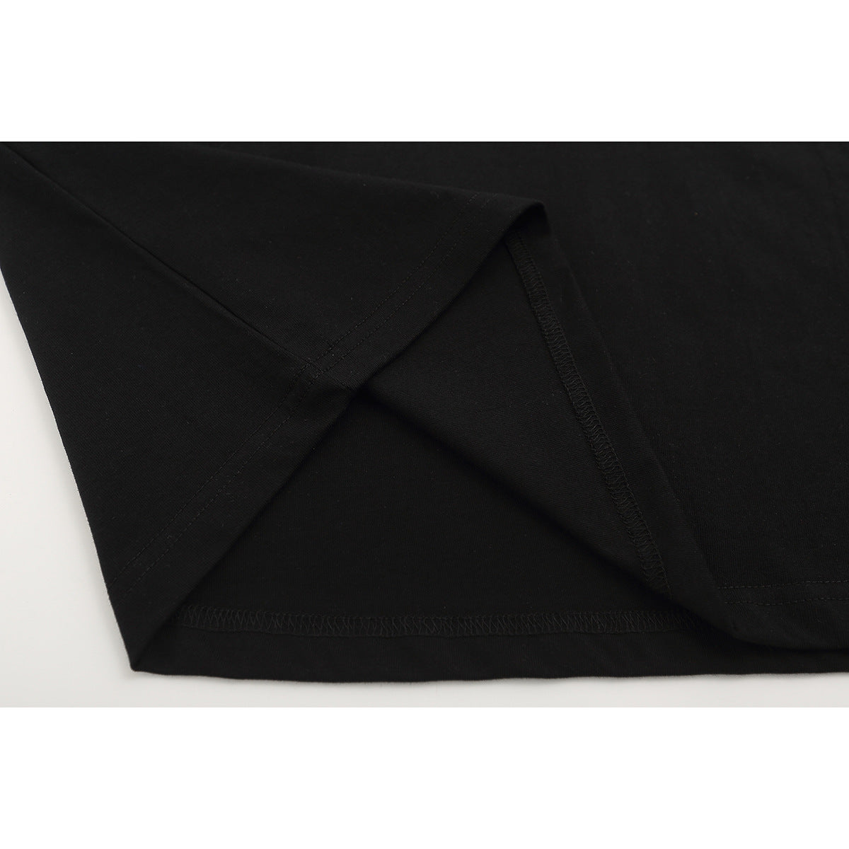 Close-up of the black T-shirt’s sleeve and hem stitching.