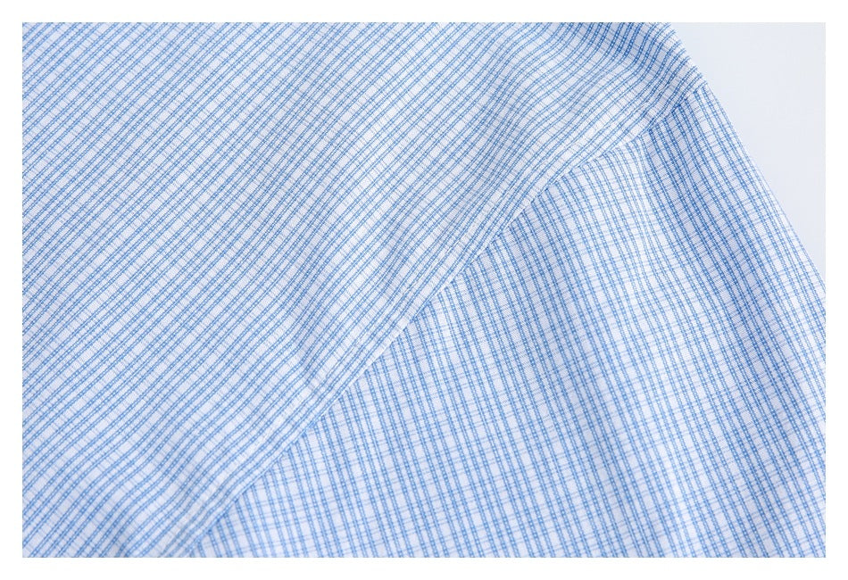 Close-up of a seam on blue-and-white check shirt fabric.